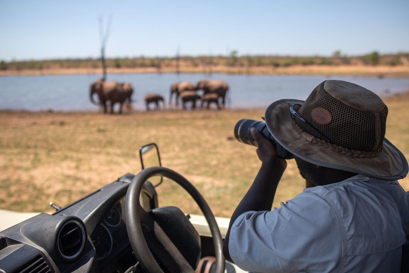 A guide watches elephants at a waterhole on a game drive from Bumi Hills.