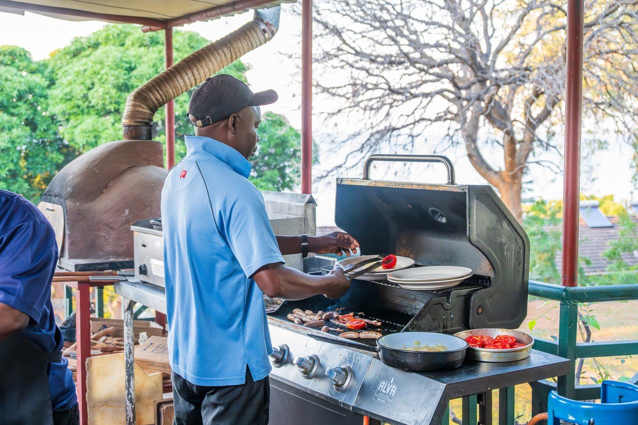 Staff grilling a braai lunch on the deck at Cutty Sark Lodge.