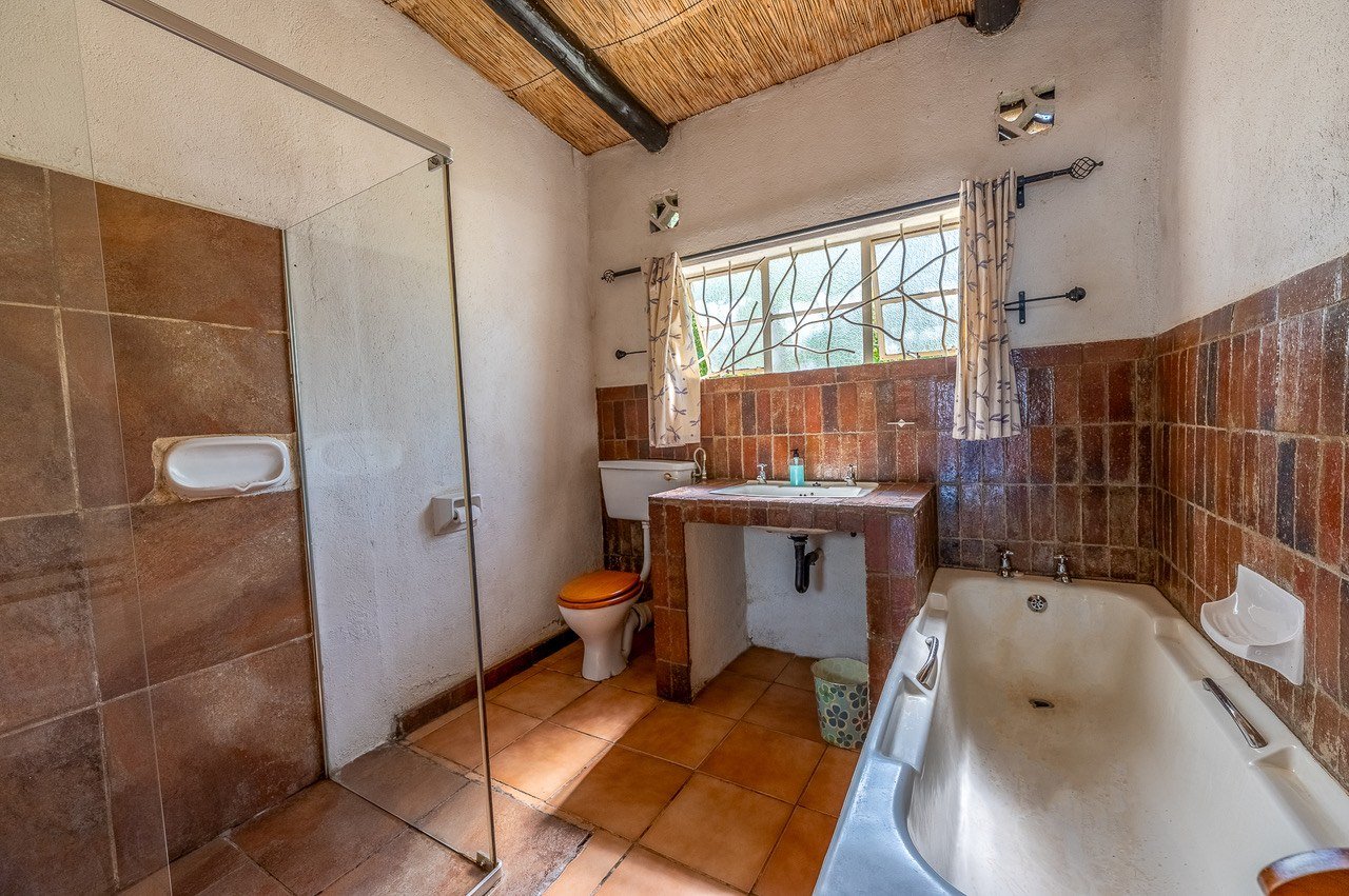 Terracotta-tiled bathroom with a bathtub and shower at Fisherman's Cove.