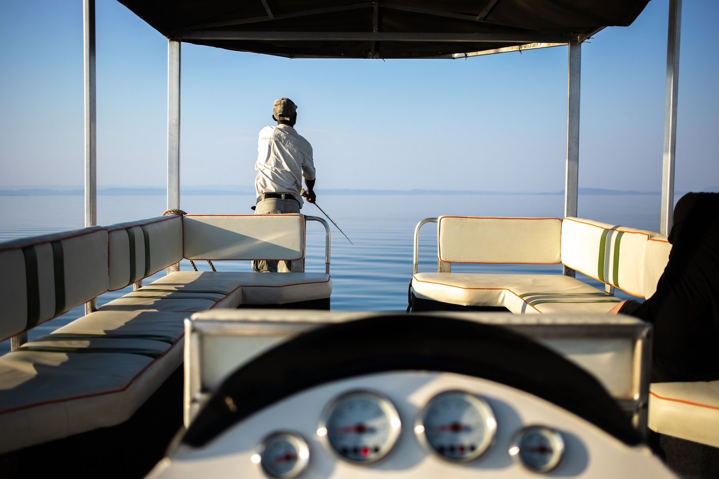 Crew member fishing from the bow of the Lady Jacqueline at dawn.