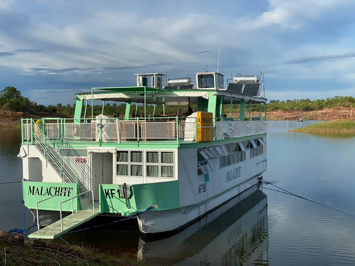 Malachite moored at a grassy Lake Kariba shoreline under evening light, Matusadona.