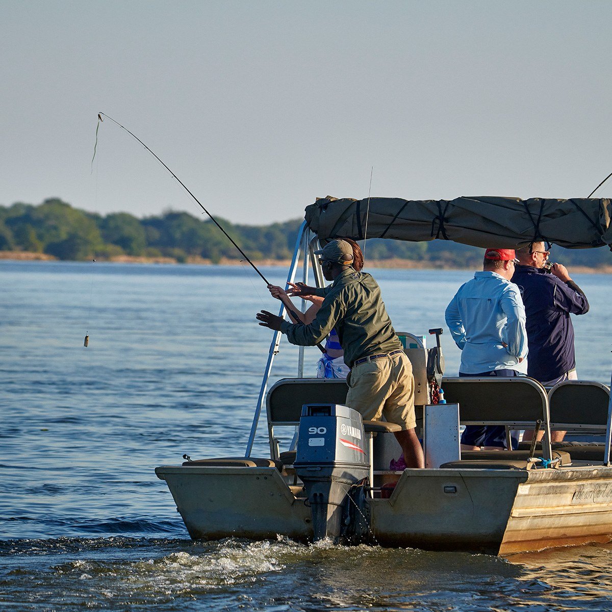 Guide and guests tigerfishing from a small boat on an MV Matusadona outing.