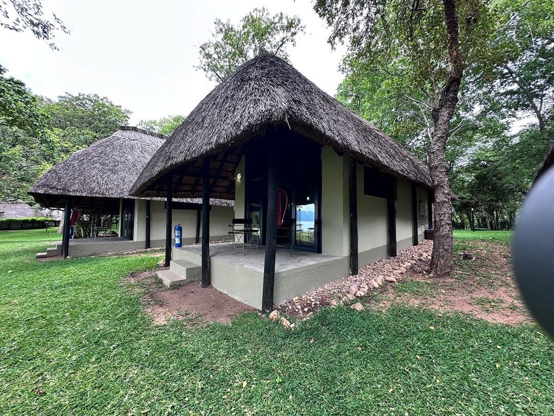 Thatched guest chalet with open deck and lake view at Spurwing Island