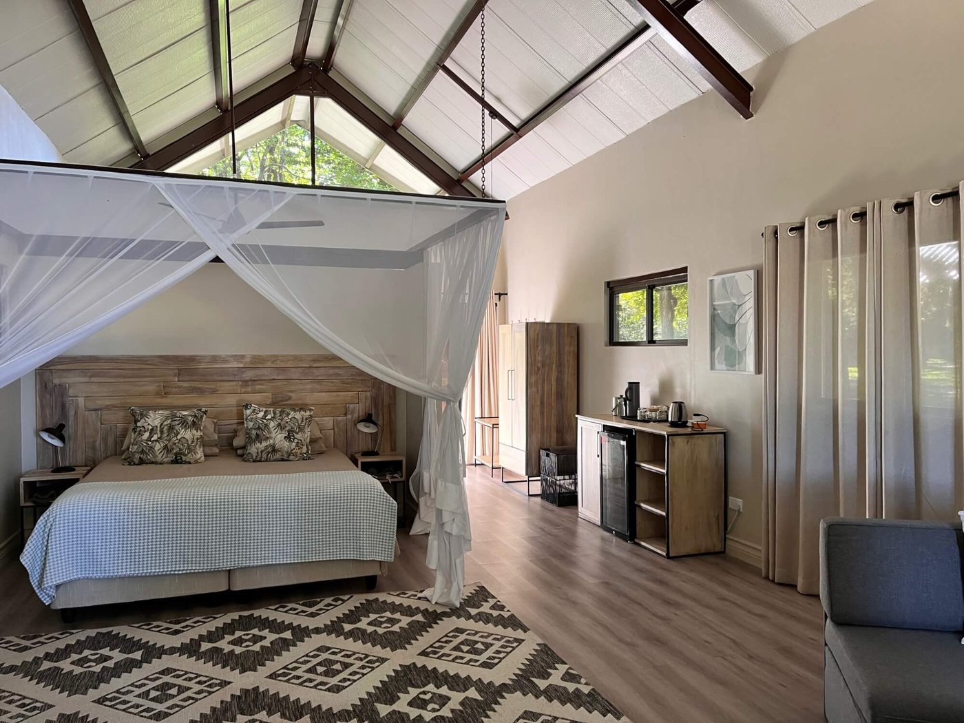 Canopied bed under woven pendant lights in a Spurwing Island cottage.